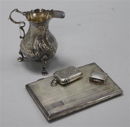 A Georgian silver cream jug, a silver cigarette case, a silver vesta case and a silver pill box.